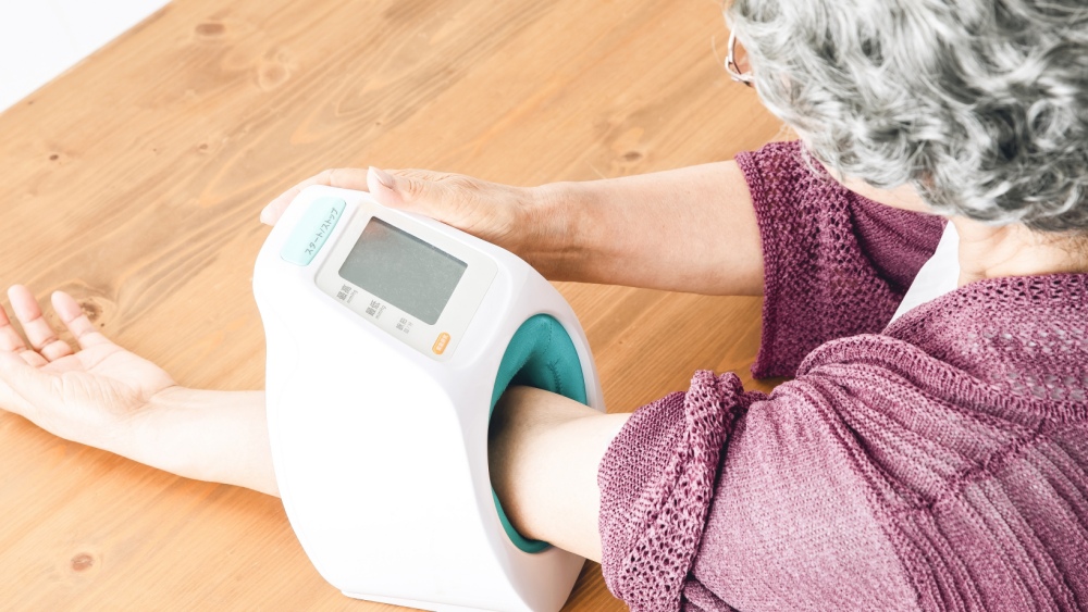 血圧を測定する高齢女性